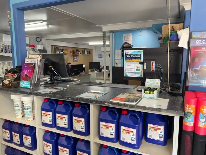 The Pool Pro counter, with pool chemicals racked along the shelves underneath it.